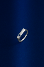 Silver ring with a blue gemstone on a blue background