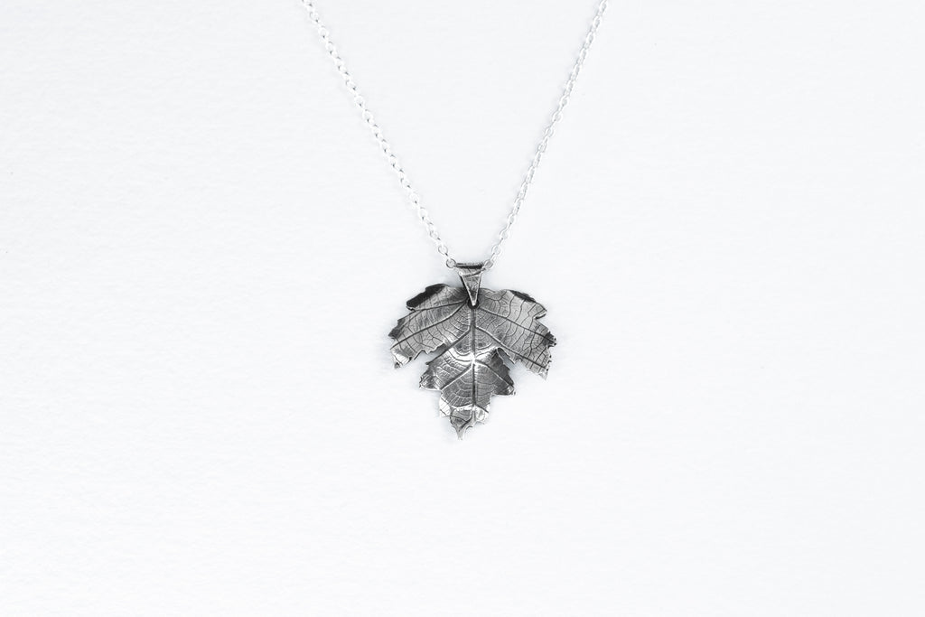 Silver leaf-shaped pendant on a white background