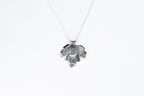 Silver leaf-shaped pendant on a white background