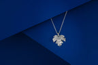 Silver leaf-shaped pendant on a blue background