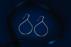 Pair of silver teardrop earrings on a dark blue background