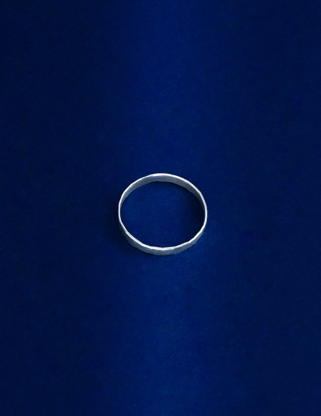 Thicker Ring Lying Flat, Silver ring on a blue background