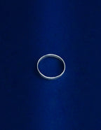 Thicker Ring Lying Flat, Silver ring on a blue background