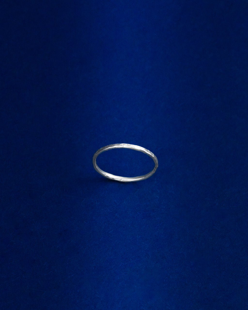 Thin Silver ring on a blue background