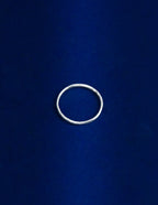 Thin Ring Lying Flat, Silver ring on a blue background
